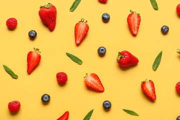 Fresh blueberries and strawberries on yellow background