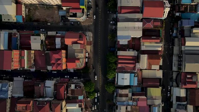 Drone footage in a asian city, people are walking, cars and motorbikes are going around