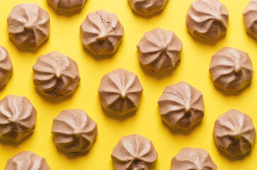 Chocolate meringue cookies on yellow background.