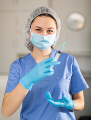 Nurse fills a syringe with injection solution