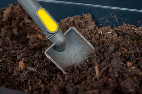 Gardening Enthusiast: Mini Shovel Digging in the Balcony Soil