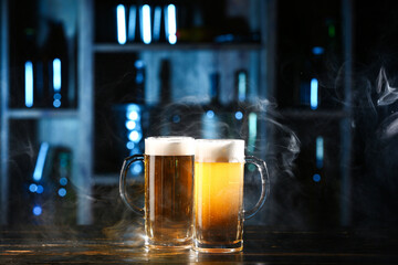 Mugs of fresh beer on table in bar
