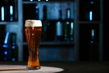 Glass of fresh beer on table in bar