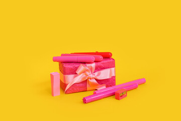 Gift box with different stationery on yellow background