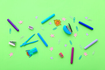 Creative composition with paper rocket, stars and different stationery on green background