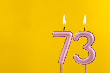 Candle 73 with flame - Birthday card on yellow luxury background