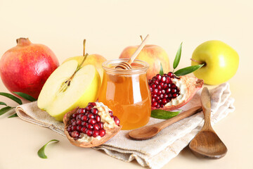 Jar of honey, pomegranate and apples for Rosh Hashanah celebration (Jewish New Year) on beige background