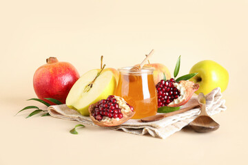 Jar of honey, pomegranate and apples for Rosh Hashanah celebration (Jewish New Year) on beige background