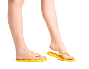 Female legs in flip-flops on white background