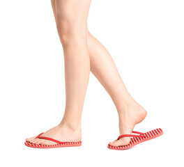 Female legs in flip-flops on white background