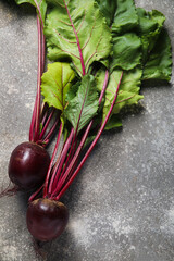 Fresh beets with green leaves on grey background