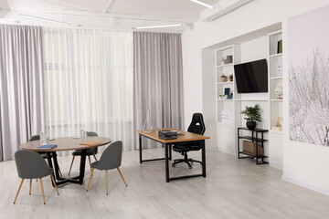 Stylish director's workplace with comfortable furniture and tv zone in room. Interior design