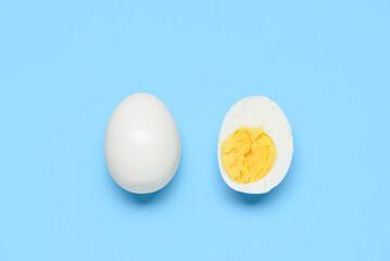 Tasty boiled egg with half on blue background