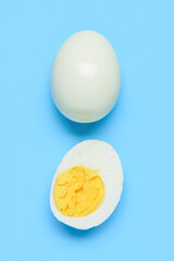 Tasty boiled egg with half on blue background