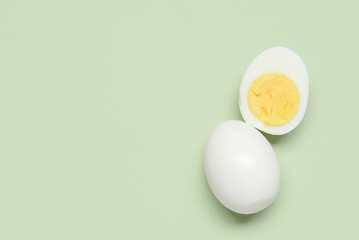 Tasty boiled egg with half on green background