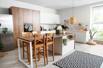 Interior of light kitchen with modern appliances on wooden table