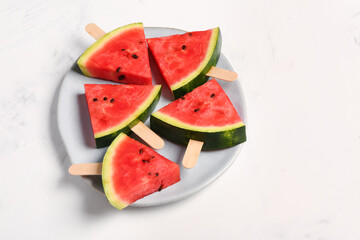 Plate with sweet watermelon sticks on white background