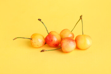 Sweet yellow cherries on color background