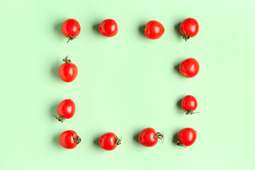 Naklejka na ściany i meble Frame made of fresh cherry tomatoes on green background