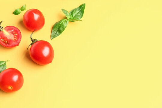 Fresh cherry tomatoes and basil on yellow background