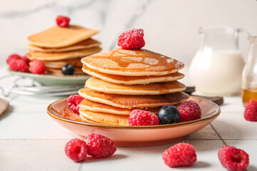 Plate of tasty pancakes with raspberries on table