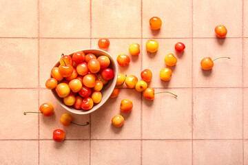 Naklejka na ściany i meble Bowl with sweet yellow cherries on pink tile background