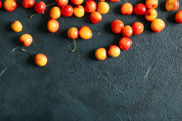 Fototapeta na wymiar Many sweet yellow cherries on dark background