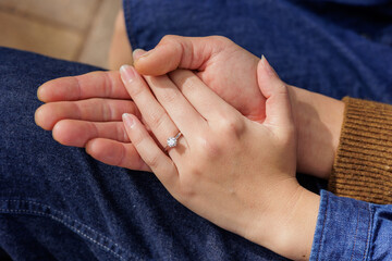 婚約指輪を付けたカップルの手