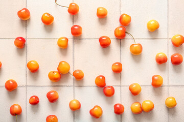 Many sweet yellow cherries on white tile background