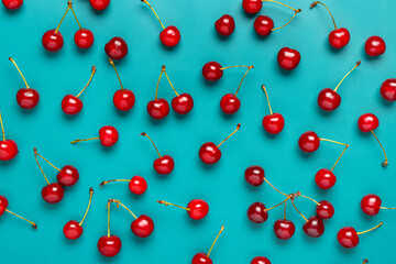 Fresh red cherries scattered on a vibrant teal background, healthy fruit and summer harvest, the bright colors and fresh appearance emphasize nutrition and deliciousness © Pixel-Shot