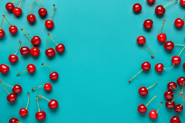 Naklejka na ściany i meble Many red sweet cherries on blue background