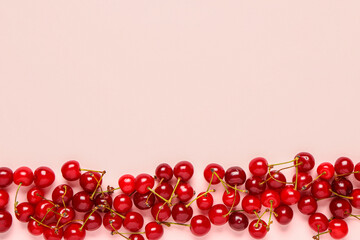 Many red sweet cherries on pink background