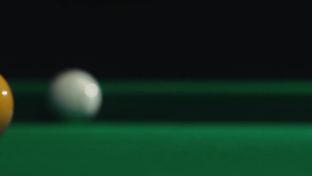 A ball hits a white ball. In the background, a white