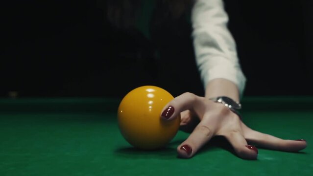 Girl puts a billiard ball in the center. Woman playing