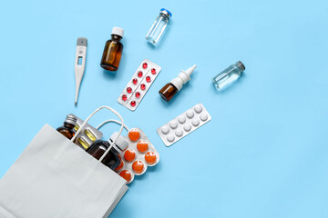 Shopping bag with different medicines on blue background