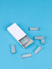 Close up stack of metal staples for stapler on a wooden table