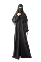 muslim woman wearing a black hijab or niqab and long dress standing in white background rising right hand