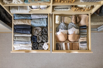 Modern wardrobe with stylish women's clothing. Drawer with underwear, t-shirts, socks and shorts. The concept of storage and order.