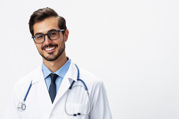 Male smile doctor in a white coat and eyeglasses and a stethoscope looks at the camera on a white isolated background, copy space, space for text, health