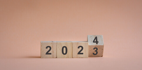 Wood cubes or blocks on table, turn of year from 2023 to 2024.