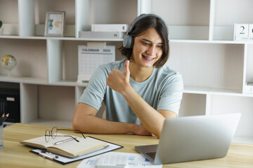 Distance education concept, Teen boy wear headphone and make gestures while listen lecture online