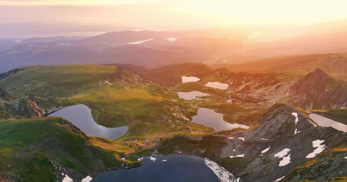 Flying over mountain peaks, hills, Seven Rila Lakes and clouds, scenic sunrise light, 4K video of Bulgaria nature