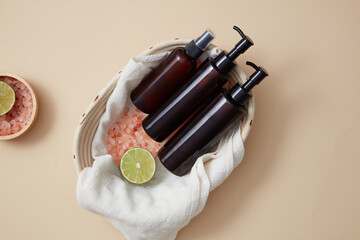 Empty label pump bottles and spray bottle displayed in a basket with a bowl of pink salt and lime...