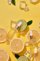 Blank label transparent dropper bottles decorated with lemon and lime cut in round slices and ices....