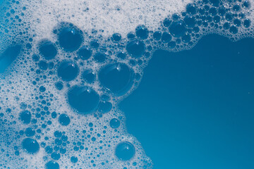 Detergent foam bubble on water. Blue background, Soap sud