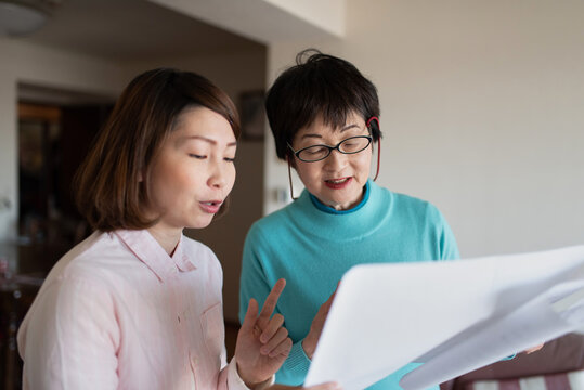 笑顔で歌を歌うシニア女性とミドル女性