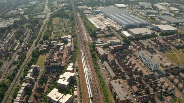 Aerial shot over trains passing between residential town and Warehouse district Basingstoke UK