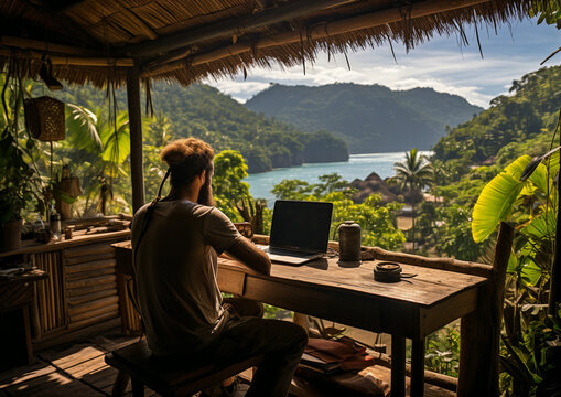 A digital nomad man working remotely in the tropic over looking the mountain and sea