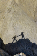 Shadow of two people on rock mountain