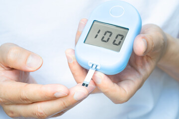 hand of people check diabetes and high blood glucose monitor with digital pressure gauge. Healthcare and Medical concept